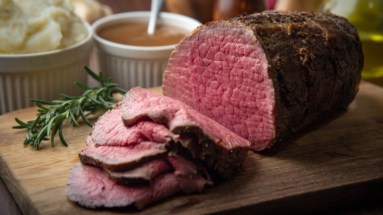 Slice eye round roast on a cutting board