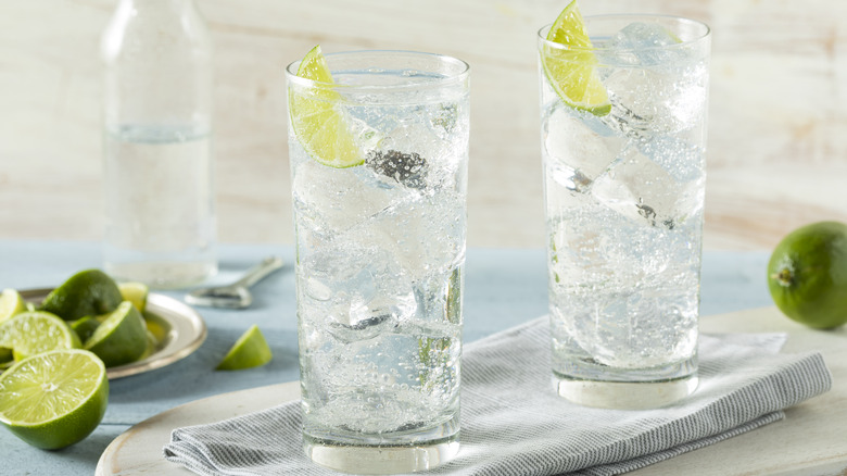 Two highball cocktails with lime wedges