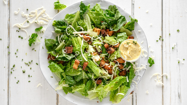 Caesar salad with shaved cheese and dressing