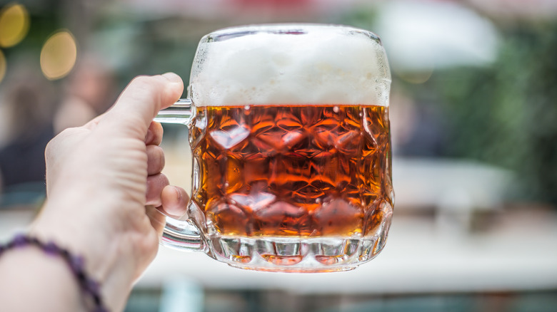 hand holding glass of beer
