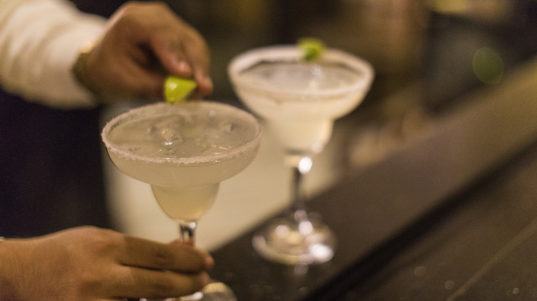 bartender garnishing margaritas with lime