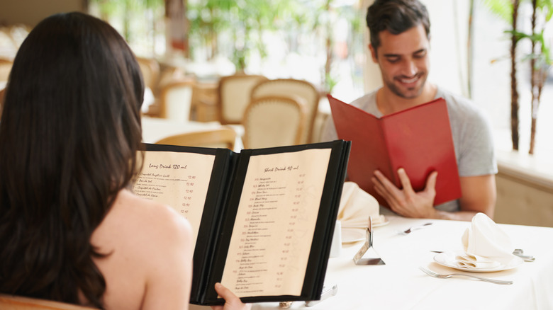 Couple looking at menu at fine restaurant