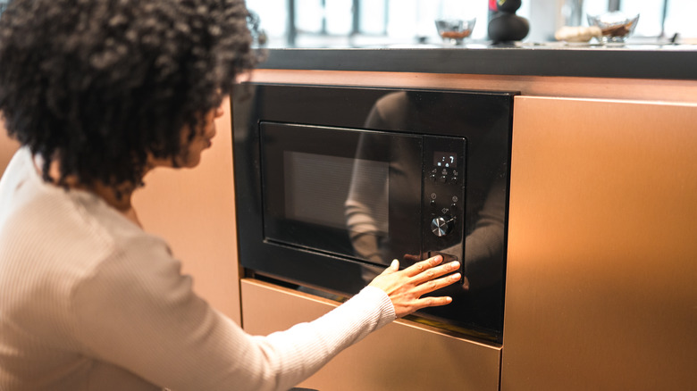 Woman using a microwave