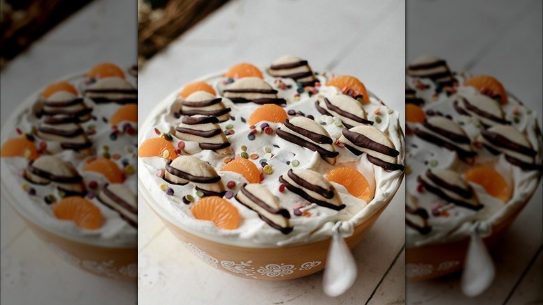 A bowl of cookie salad, with the whole cookies and mandarin slices nestled in Cool Whip