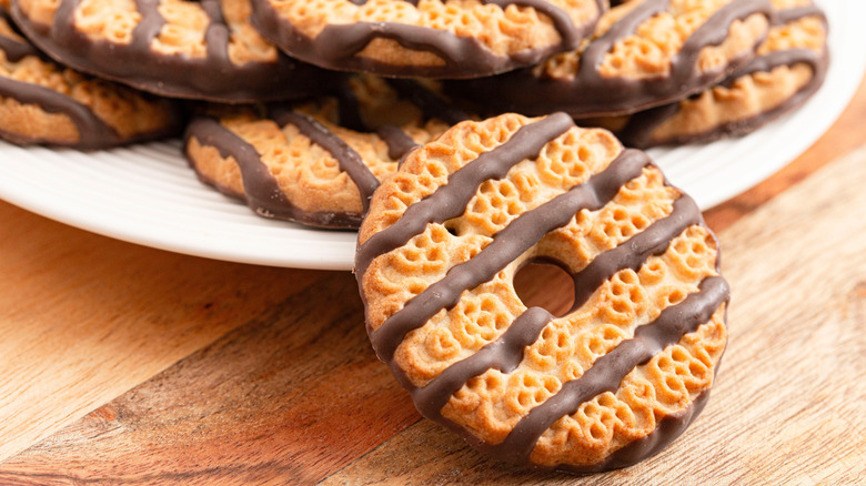 Close up of a fudge stripe cookie resting on the edge of a white plate