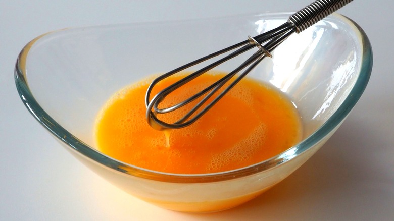 Eggs in bowl with mini whisk for scramble