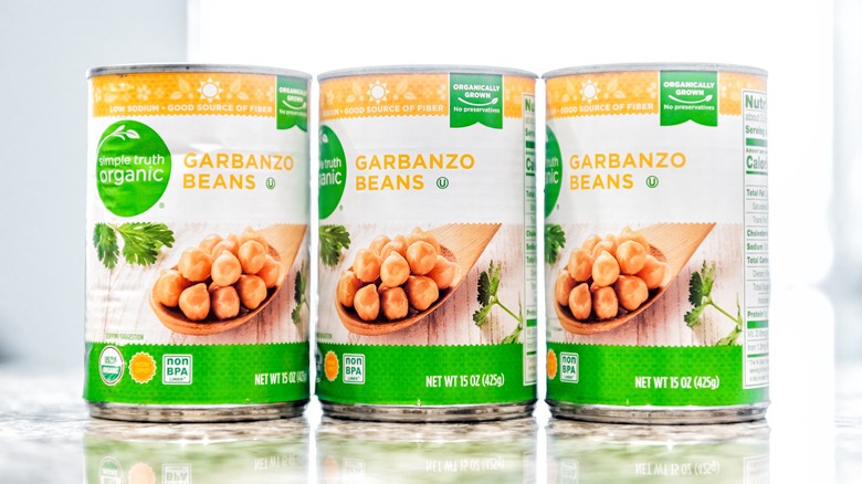 Three cans of garbanzo beans on countertop