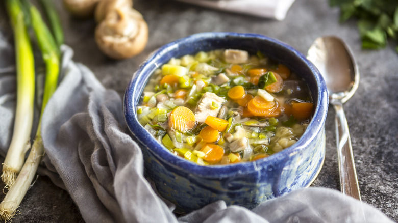 Bowl of chicken and rice soup with mushrooms and peas