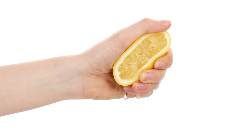 Hand squeezing lemon half