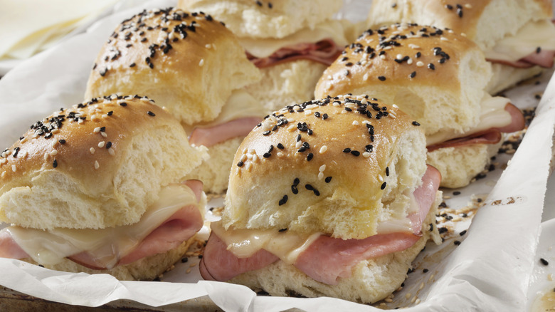 Sliders with ham cheese poppy seeds on baking tray