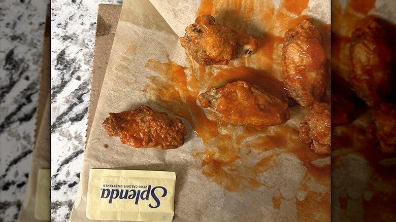 Domino's buffalo wings sit next to a Splenda packet for a size comparison
