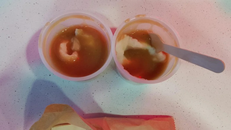 Two small containers of KFC mashed potatoes and gravy
