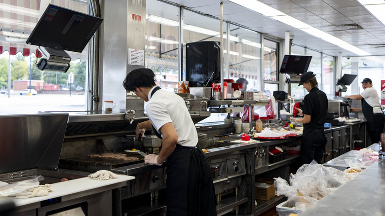 Fast food restaurant worker cooking burgers