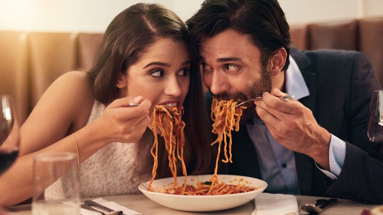 couple sharing plate of spaghetti