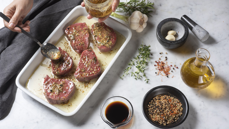 Person marinating steaks with marinade