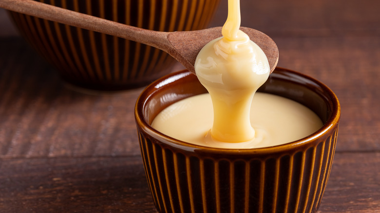 condensed milk being poured onto spoon and into bowl