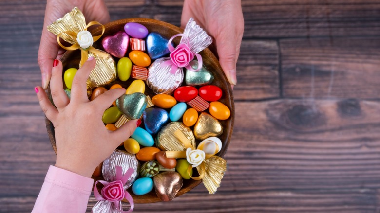 woman taking candy from bowl
