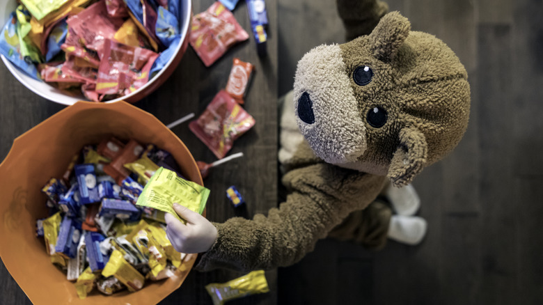 child in costume taking candy