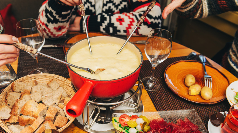 Diners eating bread and fondue