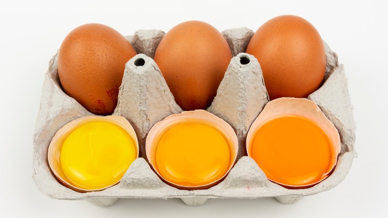 Three eggs with different yolk colors