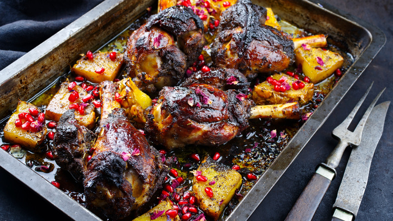 Pan of traditional Australian roast lamb with pineapple and pomegranate