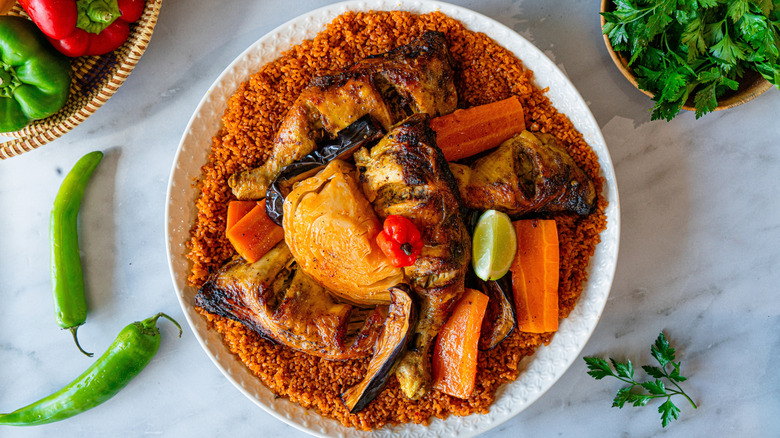 Overhead view of a dish of thieboudienne with couscous, roasted veggies, and chicken