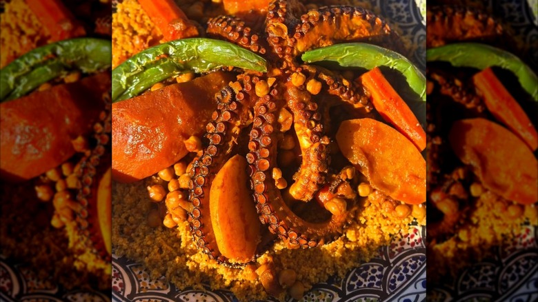 Cooked octopus and vegetables atop Tunisian couscous