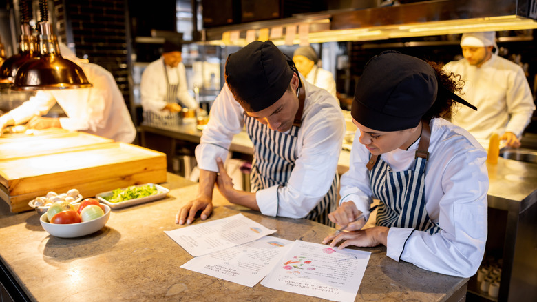 kitchen staff looking at menus