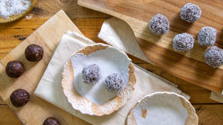 Prunes next to flour, herbs, and a mixing bowl on a counter