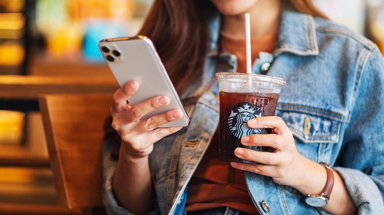 Woman on phone with Starbucks drink