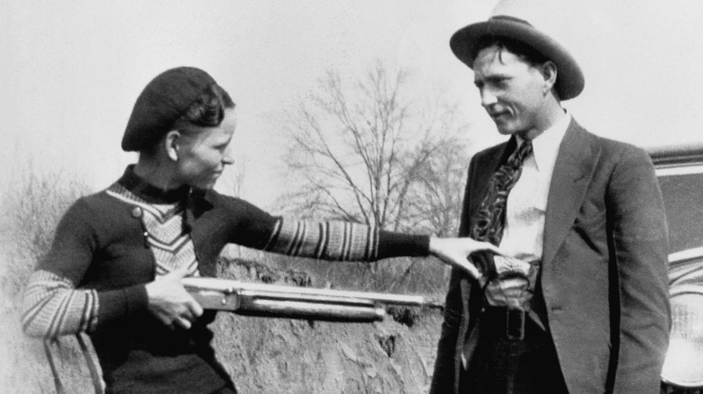 Black and white photo of Bonnie & Clyde posing with shotgun