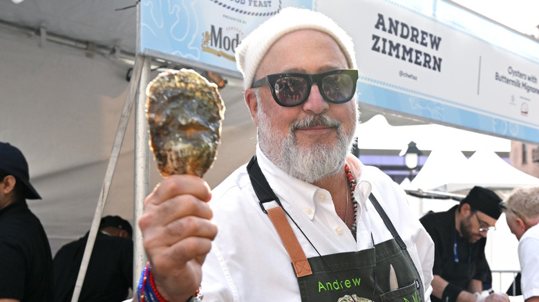 Andrew Zimmern holds up a large mollusc at the Catch of the Day: A Seafood Fest by Modelo in October of 2025