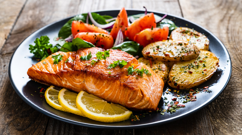 Grilled salmon with vegetables on dinner plate