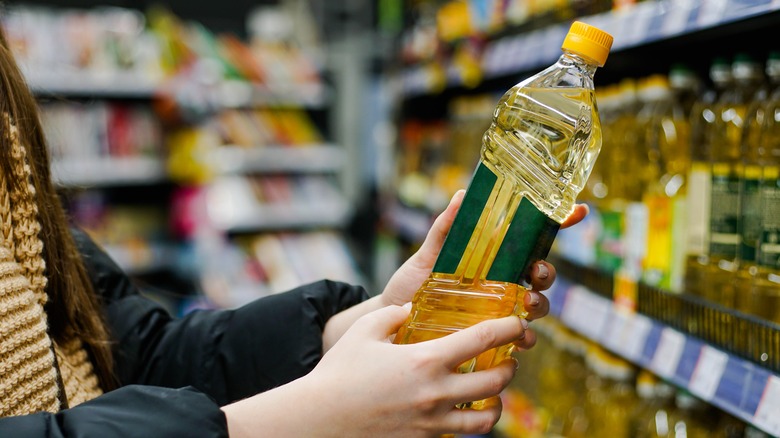 Person looking at oil bottle in store