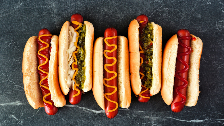 Hot dogs with various toppings on a gray background