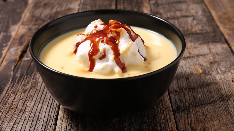 A floating island dessert in a bowl on a wooden table