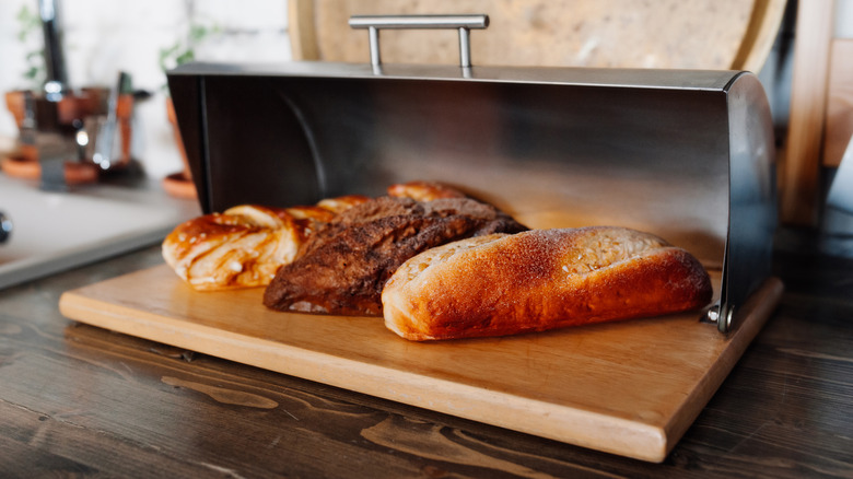 Three loaves of bread inside a bread box