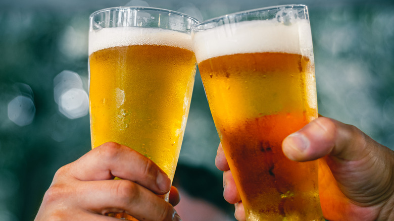 Two people raising beer glasses