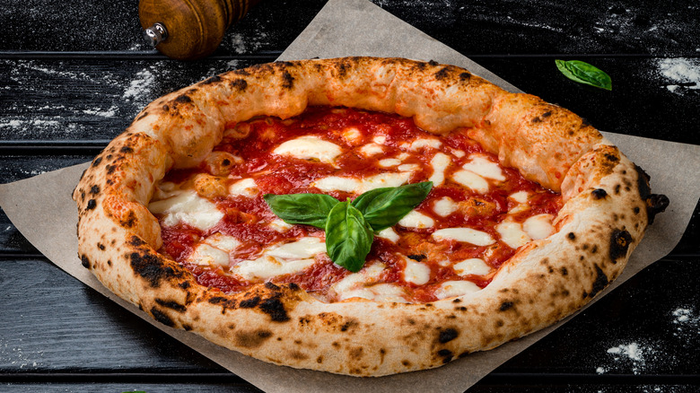 A Neapolitan pizza on a sheet of parchment paper