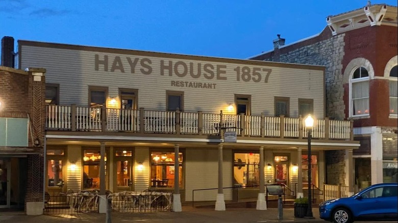 Street lights and sconces illuminate the exterior of Hays House as night falls