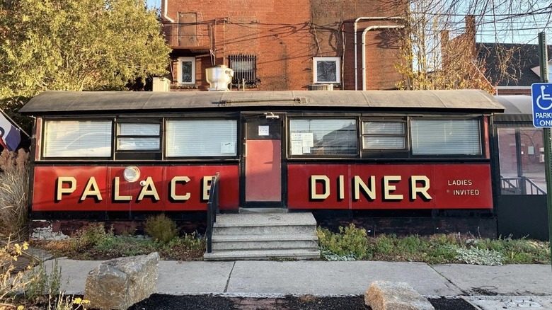 Concrete steps extend beyond the red and black exterior of the Palace Diner Pollard car