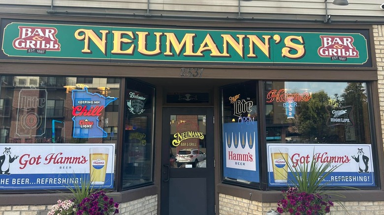 Flower pots flank the front entry of Neumann's Bar & Grill