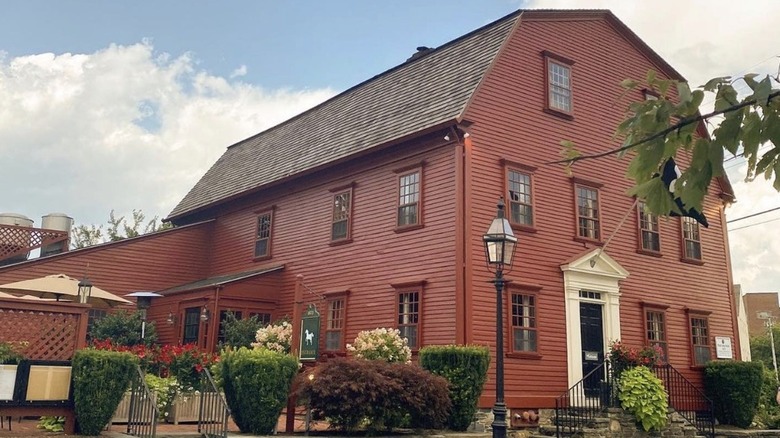Lightpost stands before the red barn structure of the White Horse Tavern