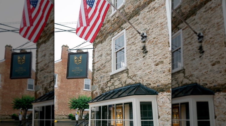 American flag hangs from the stone exterior of The Red Fox Inn