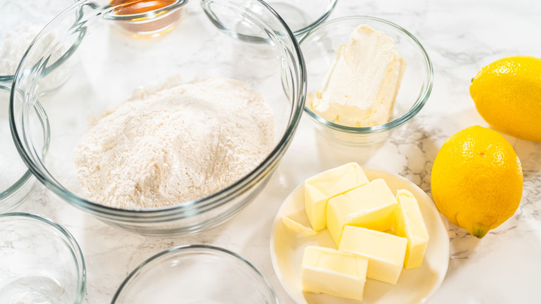 Baking ingredients, including lemons, sit on a countertop