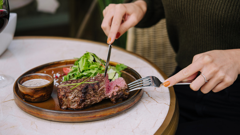 Diner cutting steak at restaurant