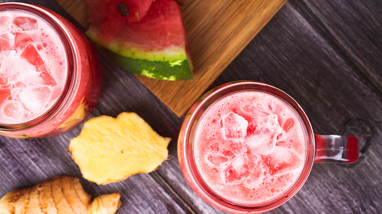 Slices of ginger and watermelon sit next to refreshing watermelon drinks.