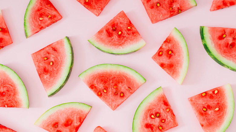 slices of watermelon against a pink background.