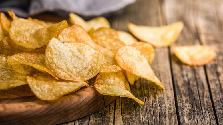 Crispy potato chips sprawled out on a wooden table