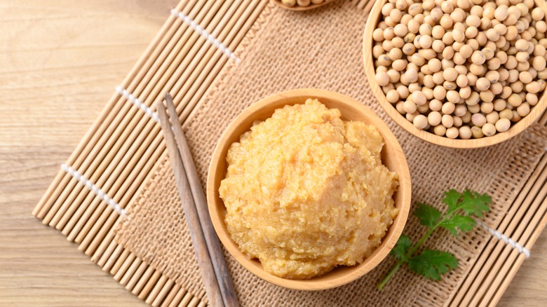 bowl of miso paste alongside chop sticks and bowl of soy beans